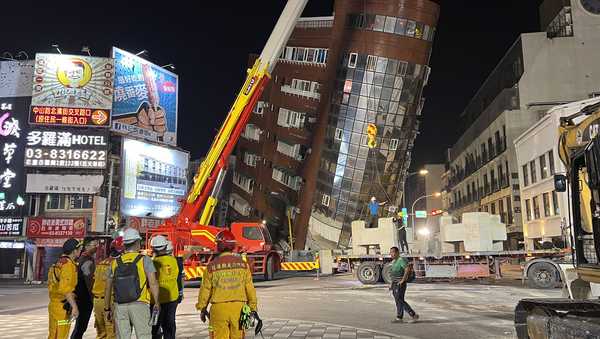 Rescue workers stand near the site of a leaning building in the aftermath of an earthquake in Hualien, Taiwan, on Wednesday, April 3, 2024. Taiwan's strongest earthquake in a quarter century rocked the island during the morning rush hour Wednesday. (AP Photo/Johnson Lai)
