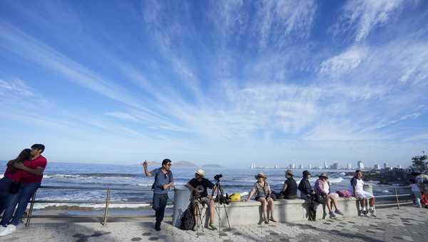 People wait to watch a total solar eclipse in Mazatlan, Mexico, Monday, April 8, 2024. (AP Photo/Fernando Llano)