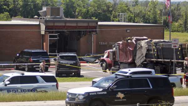 Emergency personnel work at the scene after an 18-wheeler crashed into the Texas Department of Public Safety Office in Brenham, Texas, Friday, April 12, 2024.