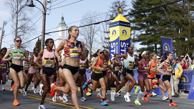 Las corredoras profesionales se toman un descanso en la línea de salida del maratón de Boston.  Lunes 15 de abril de 2024, en Hopkinton, Massachusetts.  María y Schwalm )
