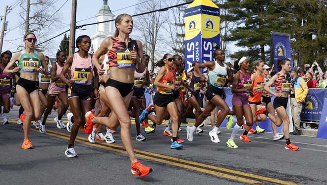Las corredoras profesionales se toman un descanso en la línea de salida del maratón de Boston.  Lunes 15 de abril de 2024, en Hopkinton, Massachusetts.  María y Schwalm )