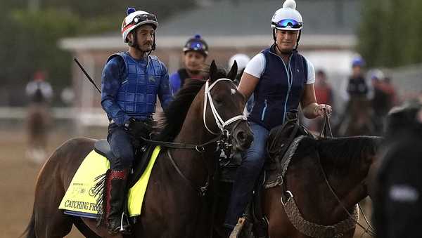 Kentucky Derby hopeful Catching Freedom, left, is led off the track after a workout at Churchill Downs Monday, April 29, 2024, in Louisville, Ky. The 150th running of the Kentucky Derby is scheduled for Saturday, May 4. (AP Photo/Charlie Riedel)