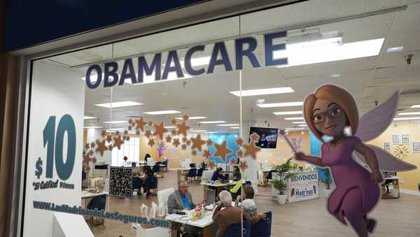 FILE - An insurance agent talks with clients inside the main location of Las Madrinas de los Seguros, Spanish for "The Godmothers of Insurance," at a shopping center in Miami, on Dec. 5, 2023. Roughly 100,000 immigrants who were brought to the U.S. are expected to enroll in the Affordable Care Act's health insurance next year under a new directive the Biden administration released Friday, May 3, 2024. (AP Photo/Rebecca Blackwell, File)