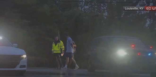 In this still image made from video provided by ESPN, Masters champion Scottie Scheffler is escorted by police after being handcuffed near Valhalla Golf Club, site of the PGA Championship golf tournament, early Friday, May 17, 2024. (ESPN via AP)