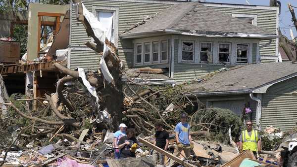 Local residents clean up debris from tornado damaged homes, Wednesday, May 22, 2024, in Greenfield, Iowa. (AP Photo/Charlie Neibergall)