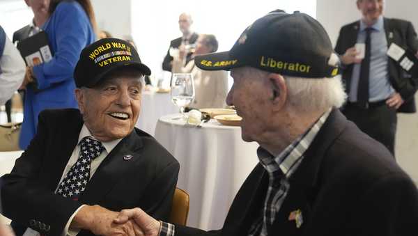 World War II veterans Andy Negra, left, and Hilbert Margol, speak to each other during an an event honoring the two on Thursday, March 14, 2024, in Atlanta.