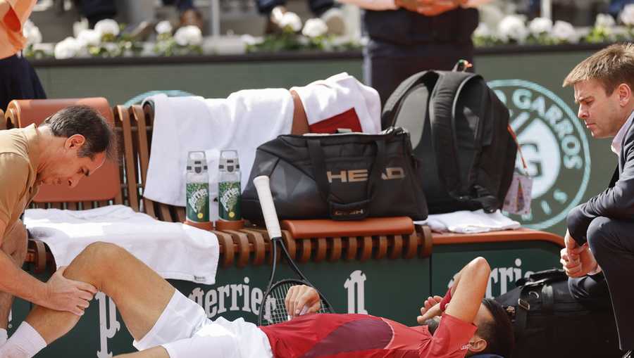 Serbia's Novak Djokovic receives medical assistance for his right knee during his fourth round match of the French Open tennis tournament against Argentina's Francisco Cerundolo at the Roland Garros stadium in Paris, Monday, June 3, 2024.