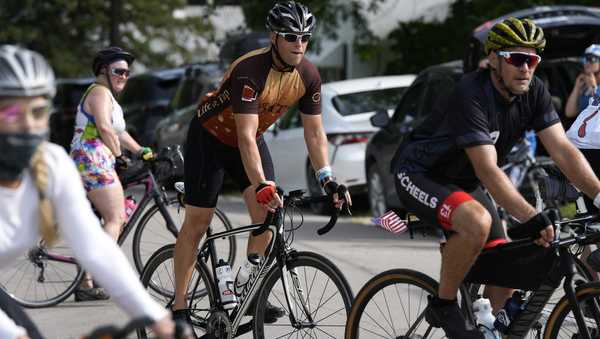 Associated Press reporter Dave Skretta, center, rides into town while riding in The Des Moines Register's annual bike ride across Iowa, also known as RAGBRAI, Tuesday, July 25, 2023, in Rippey, Iowa. (AP Photo/Charlie Neibergall)