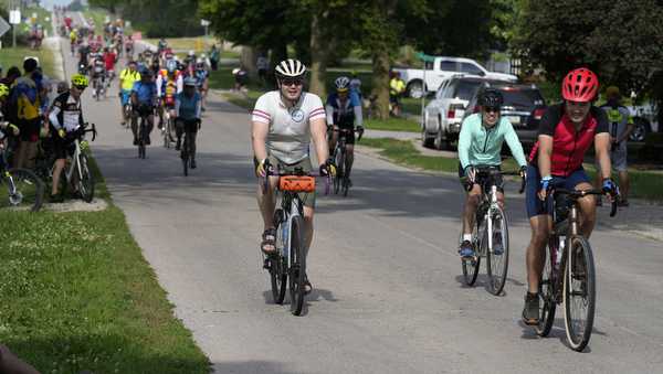 Cyclists ride on a city street while riding in The Des Moines Register's annual bike ride across Iowa, also known as RAGBRAI, Tuesday, July 25, 2023, in Rippey, Iowa. (AP Photo/Charlie Neibergall)