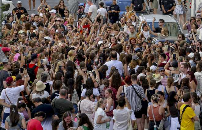 Swifties gather and sing in the city centre in Vienna on Thursday, Aug.8, 2024. Organizers of three Taylor Swift concerts in the stadium in Vienna this week called them off on Wednesday after officials announced arrests over an apparent plot to launch an attack on an event in the Vienna area such as the concerts. (AP Photo/Heinz-Peter Bader)