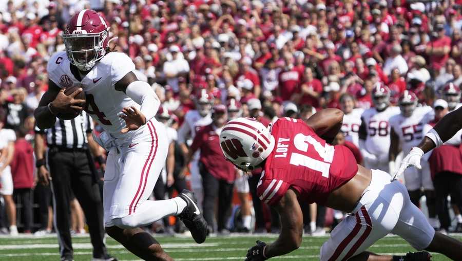 Alabama's Jalen Milroe (4) runs for a touchdown past Wisconsin's Max Lofy (12) during the first half of an NCAA college football game Saturday, Sept. 14, 2024, in Madison, Wis. (AP Photo/Morry Gash)