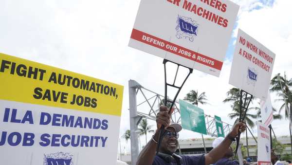 Dockworkers from Port Miami display signs at a picket line, Thursday, Oct. 3, 2024, in Miami.   (AP Photo/Marta Lavandier)