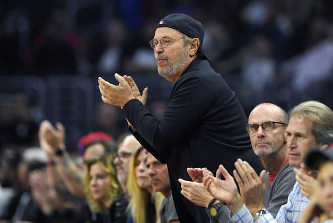 ARCHIVO - El actor Billy Crystal aplaude durante la primera mitad de un partido de baloncesto de la NBA entre Los Angeles Clippers y Detroit Pistons, el lunes 7 de noviembre de 2016, en Los Ángeles. (Foto AP/Mark J. Terrill, Archivo)