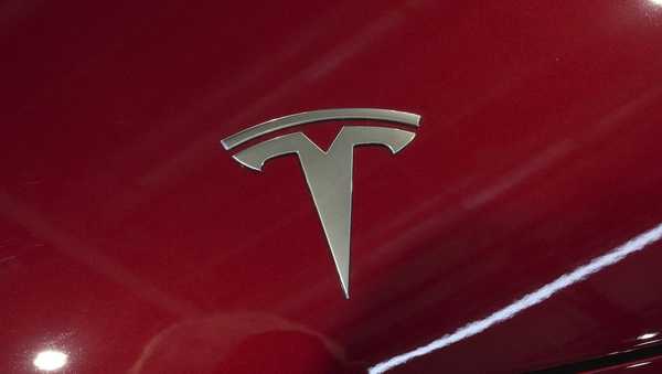 The logo of Tesla car is pictured at the Paris Auto Show, in Paris, Monday, Oct. 14, 2024. (AP Photo/Michel Euler)