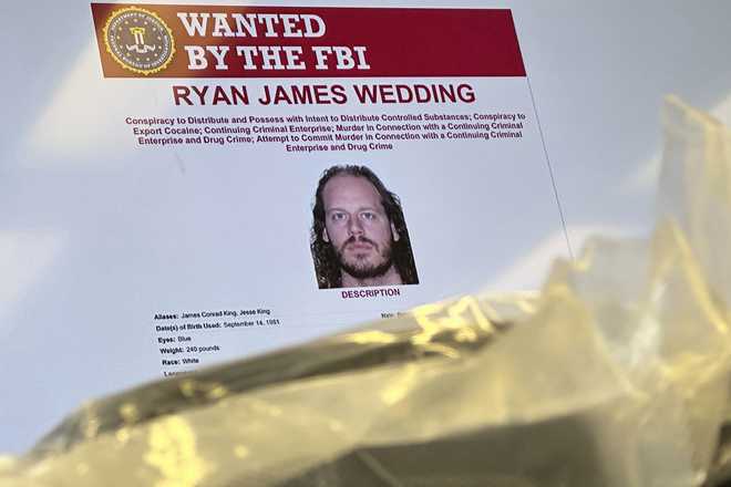 El ex snowboarder olímpico canadiense Ryan Wedding, un fugitivo de 43 años acusado de participar en una operación transnacional de tráfico de drogas, apareció en un monitor de vídeo con ladrillos de cocaína. Oficinas del FBI en Los Ángeles, jueves 17 de octubre de 2024. (Foto AP/Damián Dovarganes)