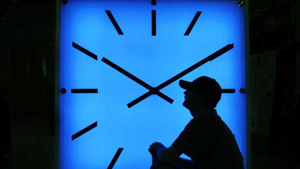 FILE - In this Oct. 30, 2008, file photo, an Electric Time Company employee adjusts the color on a clock at the plant in Medfield, Mass., days before the switch to standard time. (AP Photo/Elise Amendola, File)