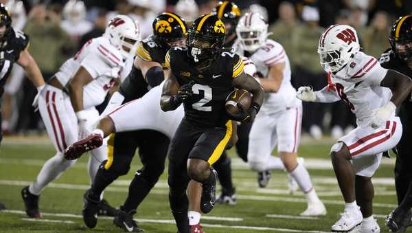 Iowa running back Kaleb Johnson (2) runs from Wisconsin linebacker Leon Lowery Jr., right, during a 16-yard touchdown run in the first half of an NCAA college football game, Saturday, Nov. 2, 2024, in Iowa City, Iowa. (AP Photo/Charlie Neibergall)