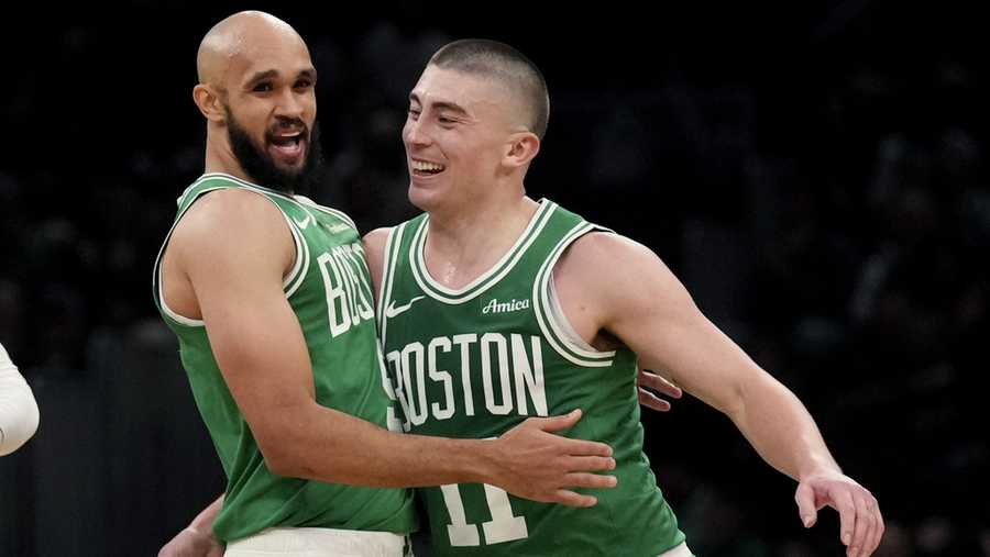 Boston Celtics guard Payton Pritchard (11) celebrates with Derrick White, left, after hitting a 3-point basket during the second half of an NBA basketball game against the Detroit Pistons, Thursday, Dec. 12, 2024, in Boston. (AP Photo/Charles Krupa)