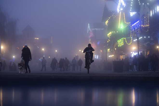 Un hombre anda en bicicleta en Front Street del distrito en Leavenworth, Washington, el martes 26 de noviembre de 2024.