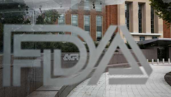 FILE - A U.S. Food and Drug Administration building is seen behind FDA logos at a bus stop on the agency's campus in Silver Spring, Md., on Aug. 2, 2018. (AP Photo/Jacquelyn Martin, File)