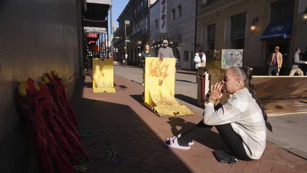 Samantha Petry, who works in the area, visits a flower memorial set up on Canal and Bourbon Street, Thursday, Jan. 2, 2025 in New Orleans.