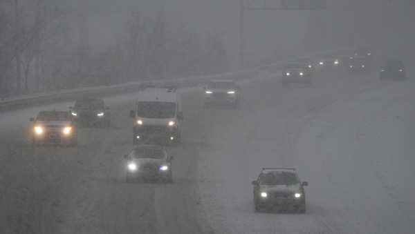 Vehicles drive along a highway during a winter storm, Sunday, Jan. 5, 2025, in Cincinnati.