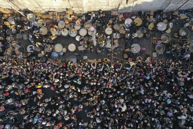 A crowd gathers outside the Umayyad Mosque during the distribution of free meals after Friday prayers in Damascus, Syria, Friday Jan. 10, 2025. (AP Photo/Ghaith Alsayed)