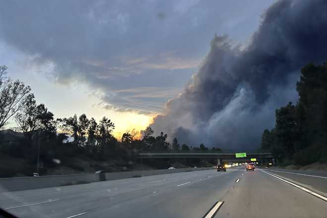 Thick smoke from the Eaton Fire is seen as Ryan Pearson, a Los Angeles-based entertainment video editor for The Associated Press, drives to his neighborhood in Altadena, California, Wednesday, Jan. 8, 2025.