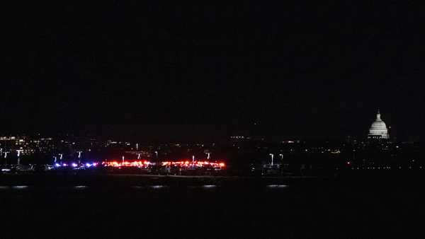 Emergency vehicles stage at Ronald Reagan Washington National Airport Wednesday, Jan. 29, 2025, in Arlington, Va. The U.S. Capitol is seen, right, across the Potomac River in Washington. (AP Photo/Kevin Wolf)