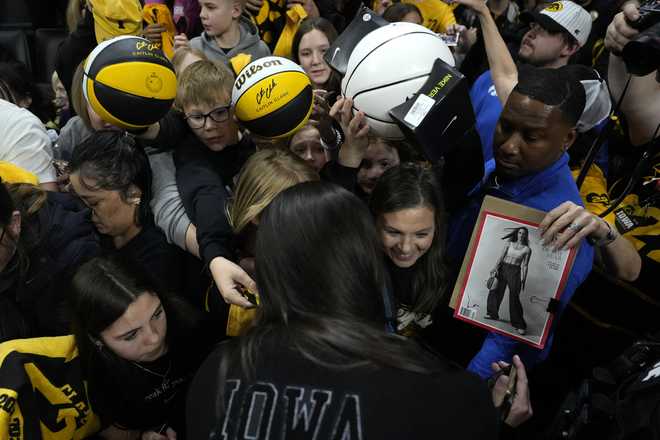 Former&#x20;Iowa&#x20;guard&#x20;and&#x20;current&#x20;Indiana&#x20;Fever&#x20;WNBA&#x20;player&#x20;Caitlin&#x20;Clark,&#x20;center&#x20;front,&#x20;gives&#x20;autographs&#x20;during&#x20;her&#x20;jersey&#x20;retirement&#x20;ceremony&#x20;after&#x20;an&#x20;NCAA&#x20;college&#x20;basketball&#x20;game&#x20;between&#x20;Iowa&#x20;and&#x20;Southern&#x20;California,&#x20;Sunday,&#x20;Feb.&#x20;2,&#x20;2025,&#x20;in&#x20;Iowa&#x20;City,&#x20;Iowa.&#x20;&#x28;AP&#x20;Photo&#x2F;Charlie&#x20;Neibergall&#x29;
