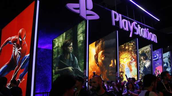 FILE - In this June 14, 2018, file people stand next to the PlayStation booth at the 24th Electronic Entertainment Expo, or E3, at the Los Angeles Convention Center.