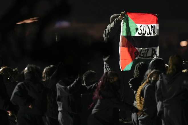 An attendee holds flags during halftime of the NFL Super Bowl 59 football game between the Kansas City Chiefs and the Philadelphia Eagles, Sunday, Feb. 9, 2025, in New Orleans. (AP Photo/Frank Franklin II)