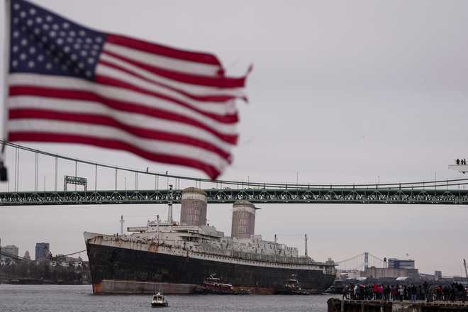 The SS United States is towed down the Delaware River between Pennsylvania and New Jersey, from Philadelphia, Wednesday, Feb. 19, 2025. (AP Photo/Matt Rourke)