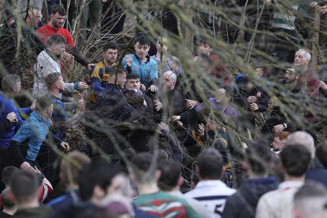 Players gather round and as they compete to get the ball during the annual Shrovetide medieval soccer match in Ashbourne, England, Tuesday, March 4, 2025.