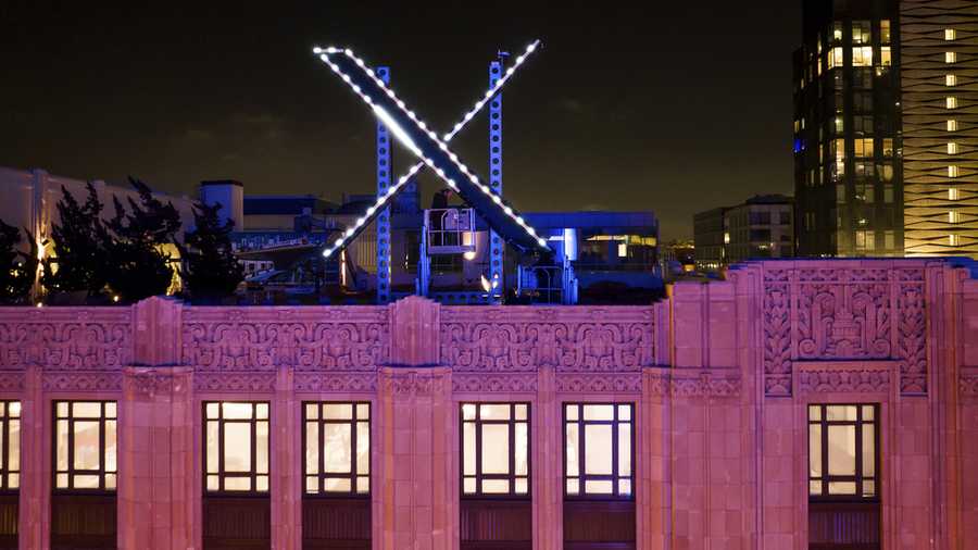 FILE - Workers install lighting on an &quot;X&quot; sign atop the company headquarters, formerly known as Twitter, in downtown San Francisco, on Friday, July 28, 2023. (AP Photo/Noah Berger, File)