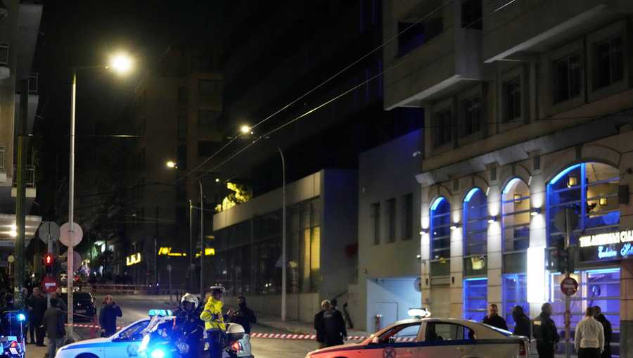 Policemen close the road after a suspected bomb explosion outside of the Hellenic Train offices the company that runs Greece&apos;s railway, the second building on the right, in Athens, Greece, Friday, April 11, 2025. (AP Photo/Petros Giannakouris)