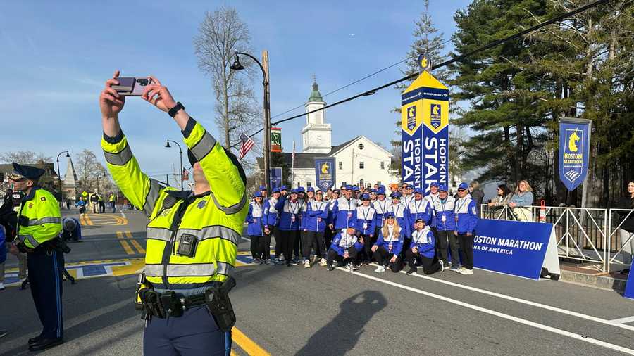 Polisi Negara Bagian Cory Hetu mengambil selfie dengan kelompok sukarelawan ras di awal Boston Marathon Senin, 21 April 2025 di Hopkinton, Mass. (Foto AP/ Jennifer McDermott)