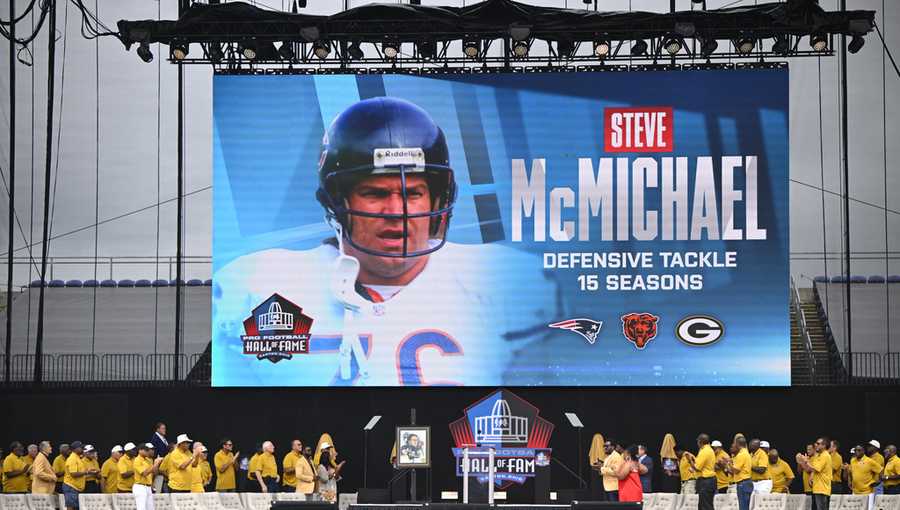 FILE - A video board displays an image of former NFL player Steve McMichael during his induction into the Pro Football Hall of Fame, in Canton, Ohio, Saturday, Aug. 3, 2024. (AP Photo/David Richard,File)