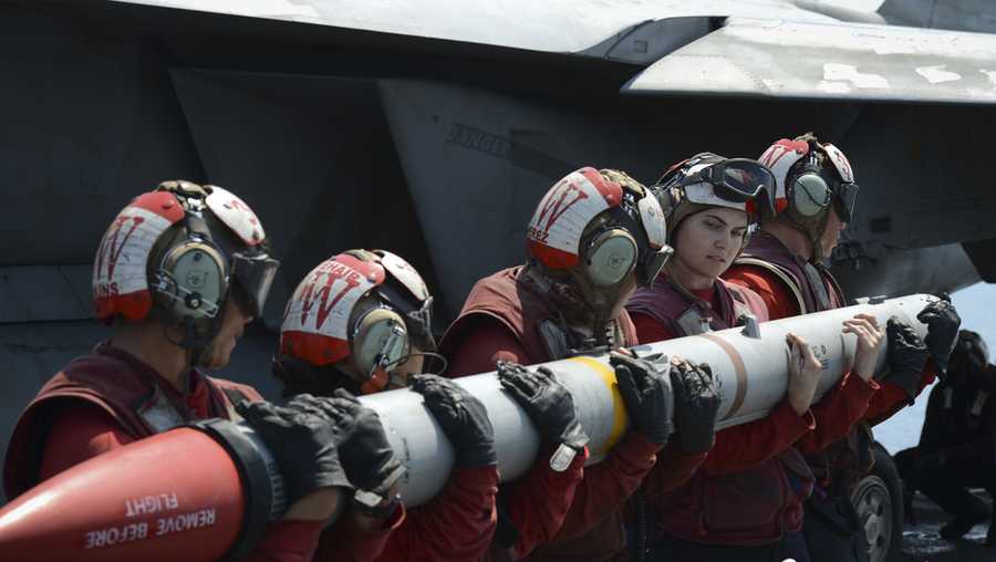 In this handout photo from the U.S. Navy, sailors load an AIM-120C missile into an F/A-18E Super Hornet aboard the aircraft carrier USS Nimitz in the Persian Gulf on Aug. 8, 2017. (Mass Communication Specialist 3rd Class Weston A. Mohr/U.S. Navy via AP)