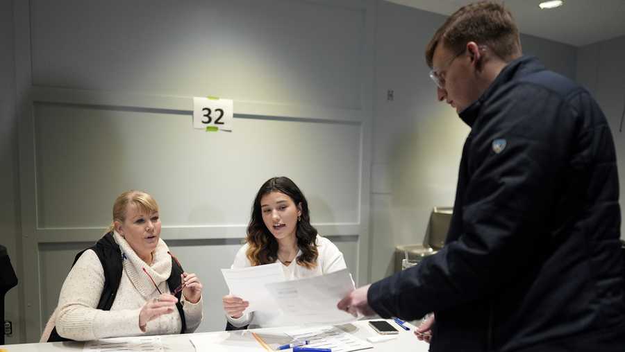 FILE - A caucus voter signs in at precinct 32 at Franklin Junior High in Des Moines, Iowa, Jan. 15, 2024. (AP Photo/Carolyn Kaster, File)
