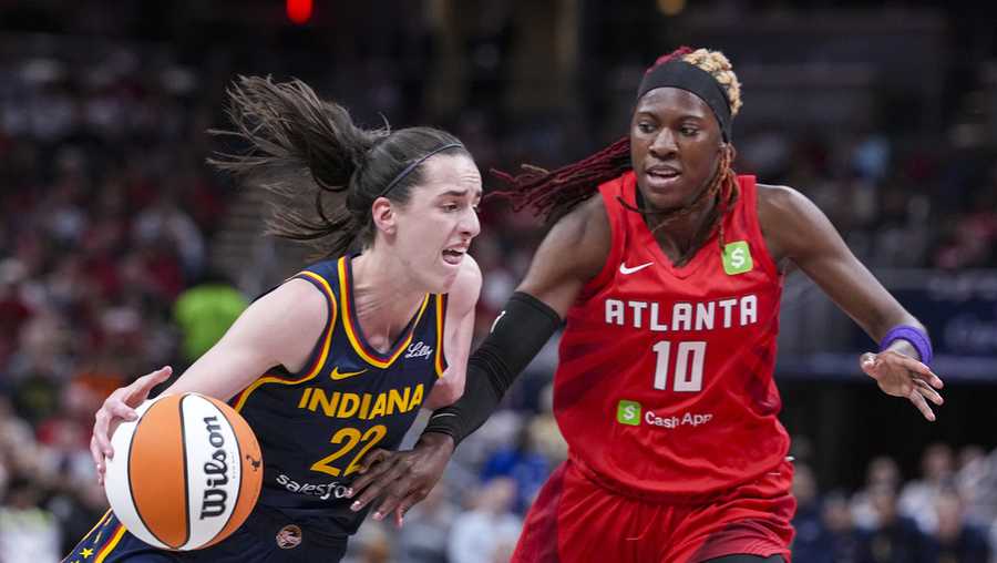 Indiana Fever guard Caitlin Clark (22) drives on Atlanta Dream guard Rhyne Howard (10) in the first half of a WNBA basketball game in Indianapolis, Tuesday, May 20, 2025. (AP Photo/Michael Conroy)