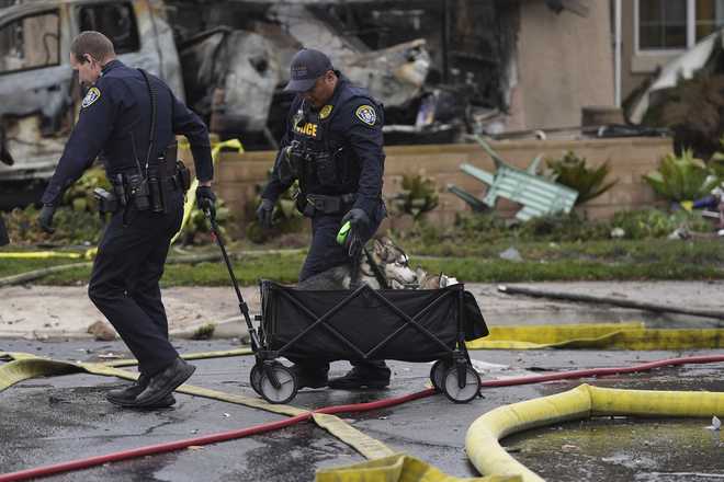 Police&#x20;help&#x20;rescue&#x20;dogs&#x20;from&#x20;a&#x20;home&#x20;after&#x20;a&#x20;small&#x20;plane&#x20;crashed&#x20;into&#x20;a&#x20;San&#x20;Diego&#x20;neighborhood&#x20;earlier,&#x20;setting&#x20;several&#x20;homes&#x20;on&#x20;fire&#x20;and&#x20;forcing&#x20;evacuations&#x20;along&#x20;several&#x20;blocks,&#x20;Thursday,&#x20;May&#x20;22,&#x20;2025.&#x20;&#x28;AP&#x20;Photo&#x2F;Gregory&#x20;Bull&#x29;