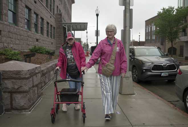 Jacque&#x20;Farnham,&#x20;60,&#x20;left,&#x20;walks&#x20;with&#x20;her&#x20;mother,&#x20;Janith,&#x20;80,&#x20;to&#x20;the&#x20;Visual&#x20;Arts&#x20;Center&#x20;at&#x20;the&#x20;Washington&#x20;Pavilion&#x20;in&#x20;Sioux&#x20;Falls,&#x20;S.D.,&#x20;on&#x20;May&#x20;20,&#x20;2025.&#x20;&#x28;AP&#x20;Photo&#x2F;Shelby&#x20;Lum&#x29;