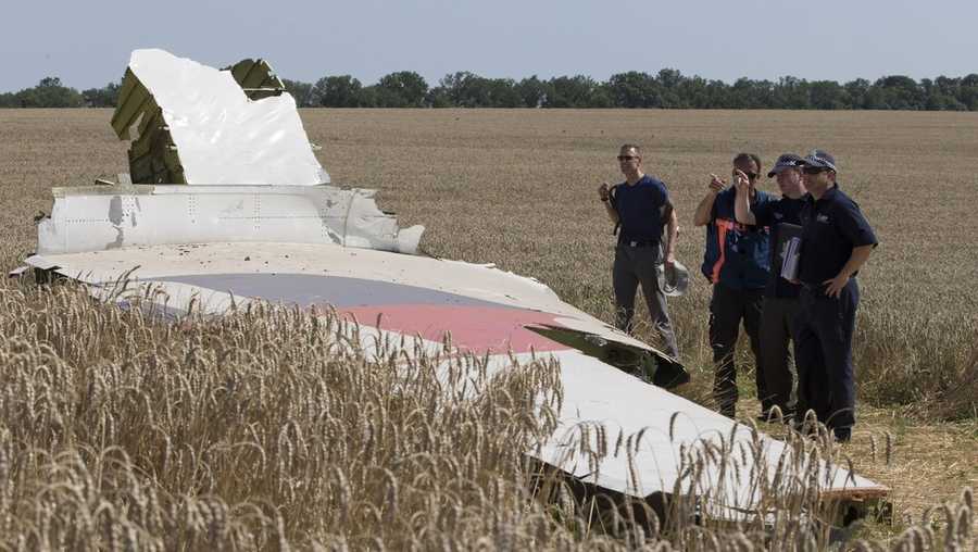 FILE - Australian and Dutch investigators examine a piece of the Malaysia Airlines Flight 17 plane, near the village of Hrabove, Russian-controlled Donetsk region of eastern Ukraine in Aug. 1, 2014.
