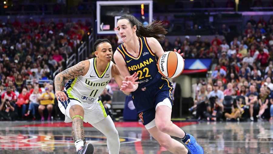 Indiana Fever&apos;s Caitlin Clark (22) goes to the basket against Dallas Wings&apos; JJ Quinerly (11) during the second half of a WNBA basketball game, Sunday, July 13, 2025, in Indianapolis. (AP Photo/Doug McSchooler)