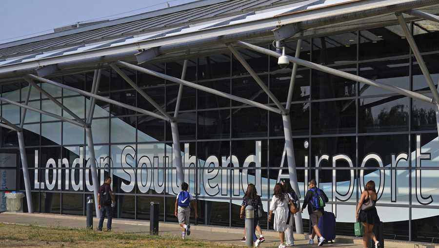 Passengers outside the terminal building at Southend Airport in Essex, where a 12-metre plane crashed shortly after take off on Sunday afternoon, Monday July 14, 2025. (Joe Giddens/PA via AP)
