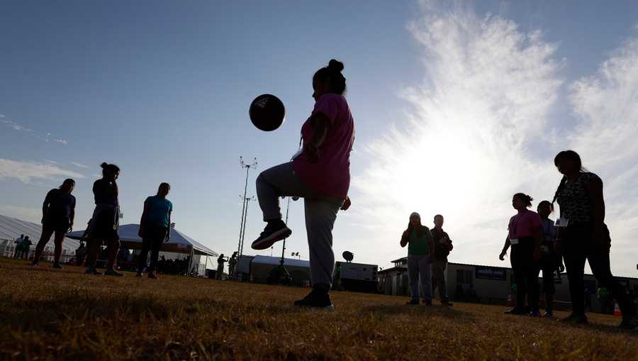 FILE - Immigrants play soccer at a new U.S. government holding center for migrant children in Carrizo Springs, Texas, July 9, 2019. (AP Photo/Eric Gay, File)