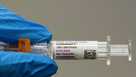 A pharmacist holds a Pfizer and BioNTech COVID-19 vaccine shot on Thursday, April 24, 2025, in Portland, Ore.