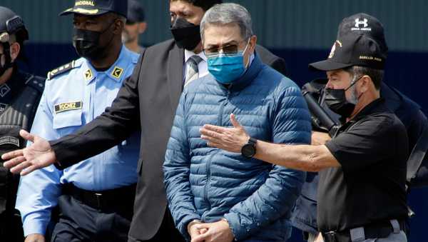 FILE - Former Honduran President Juan Orlando Hernandez, second from right, is taken in handcuffs to a waiting aircraft as he is extradited to the United States, at an Air Force base in Tegucigalpa, Honduras, April 21, 2022. (AP Photo/Elmer Martinez, File)