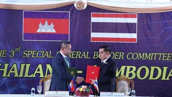 CORRECTS NAME OF THAI DEFENSE MINISTER - In this photo released by Agence Kampuchea Press (AKP), Cambodian Defense Minister Tea Seiha, left, stands with Thai Defense Minister Nattaphon Narkphanit, right, at the General Border Committee Meeting in Chanthaburi Province, Thailand Saturday, Dec. 27, 2025. (AKP via AP)